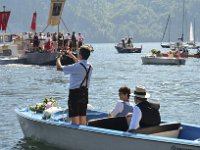 Fronleichnamsseeprozession in Traunkirchen 2017. Dieses Bild zeigt Gäste in einem Elektroboot, die die Pontons mit der Seeprozession beobachten : Fronleichnamsprozession, Fronleichnamsseeprozession, Seeprozession, Traunkirchen, Traunsee, Ponton, Zugschiff, Zugboot, Motorboot, Fahnen, Gläubige, Glaeubige, Seefahrt, Fahrt über den See, Messe, fotografieren